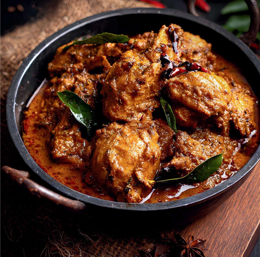 Kadhai chicken curry in a black iron kadhai with curry leaves